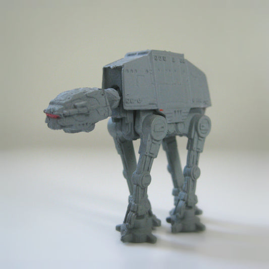 Side view of a miniature Star Wars AT-AT Walker toy.