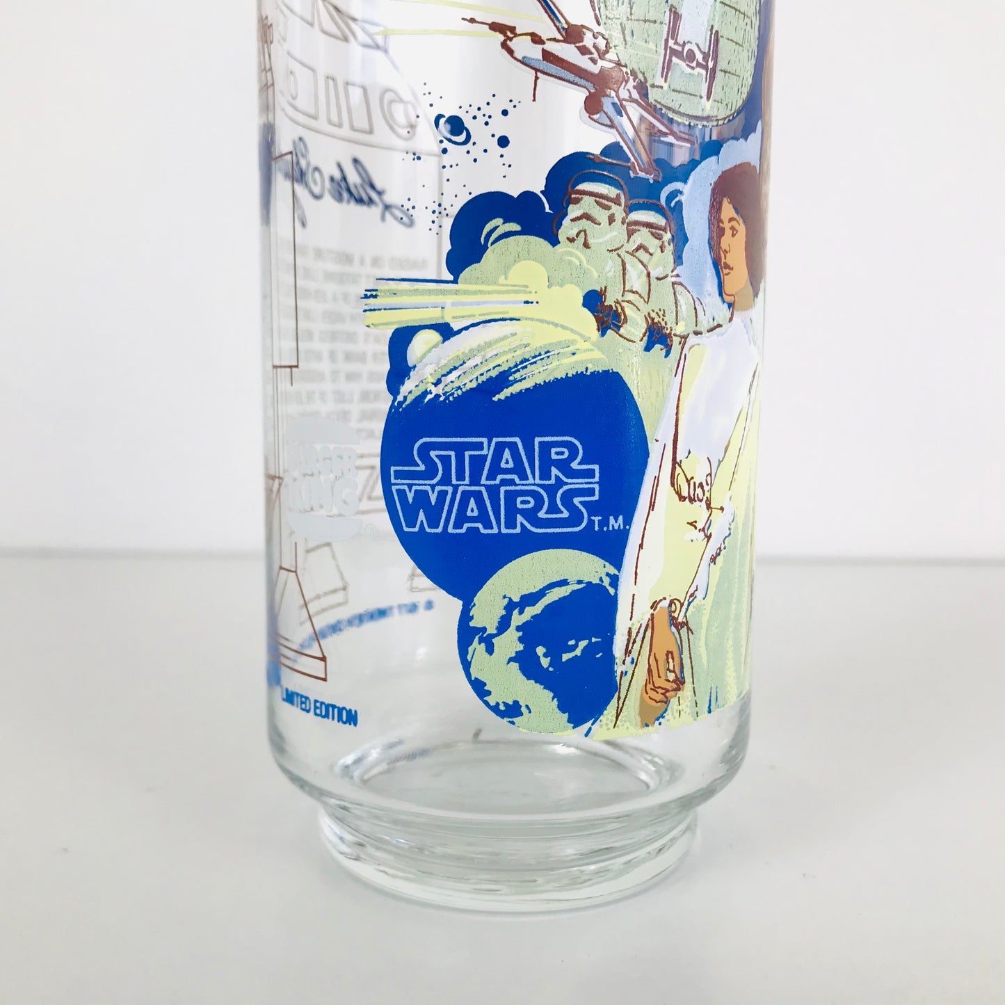 An original 1977 Star Wars collectible glass tumbler with artwork depicting several characters and planets from the film.