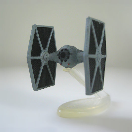 A miniature Star Wars Micro Machines Imperial TIE Fighter spaceship shown displayed on a plastic display stand.