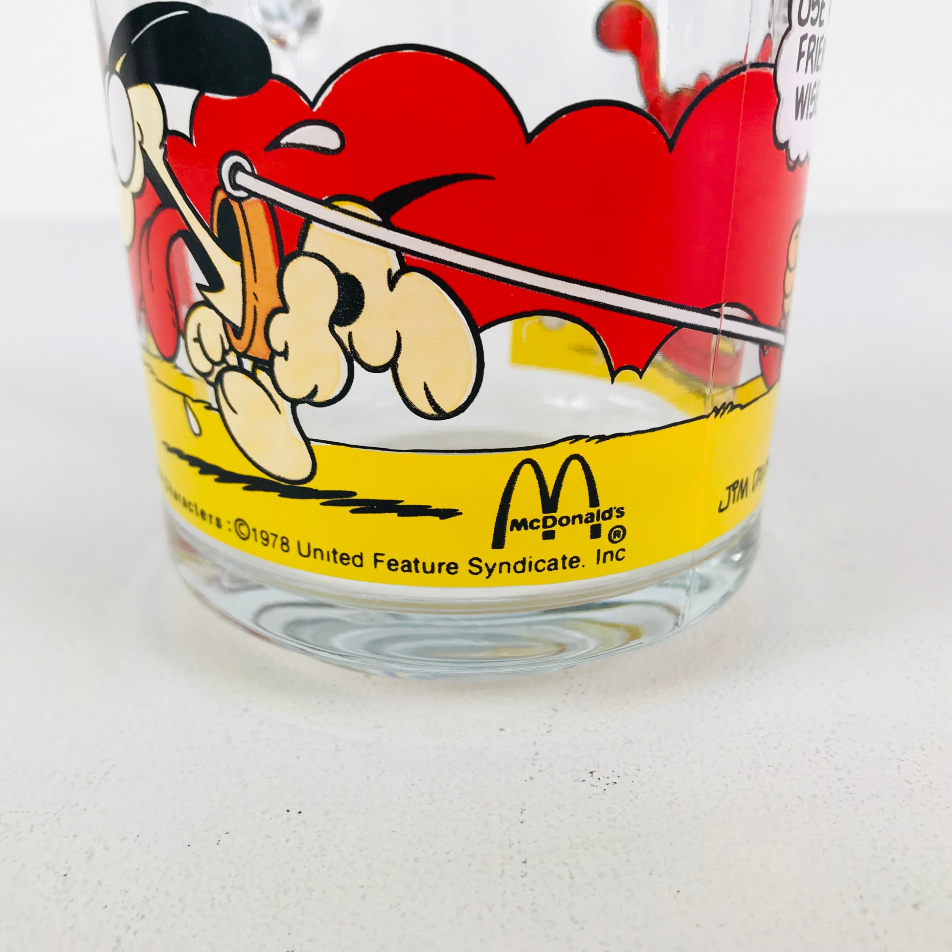 Close up of a vintage Garfield glass showing the McDonald's logo 