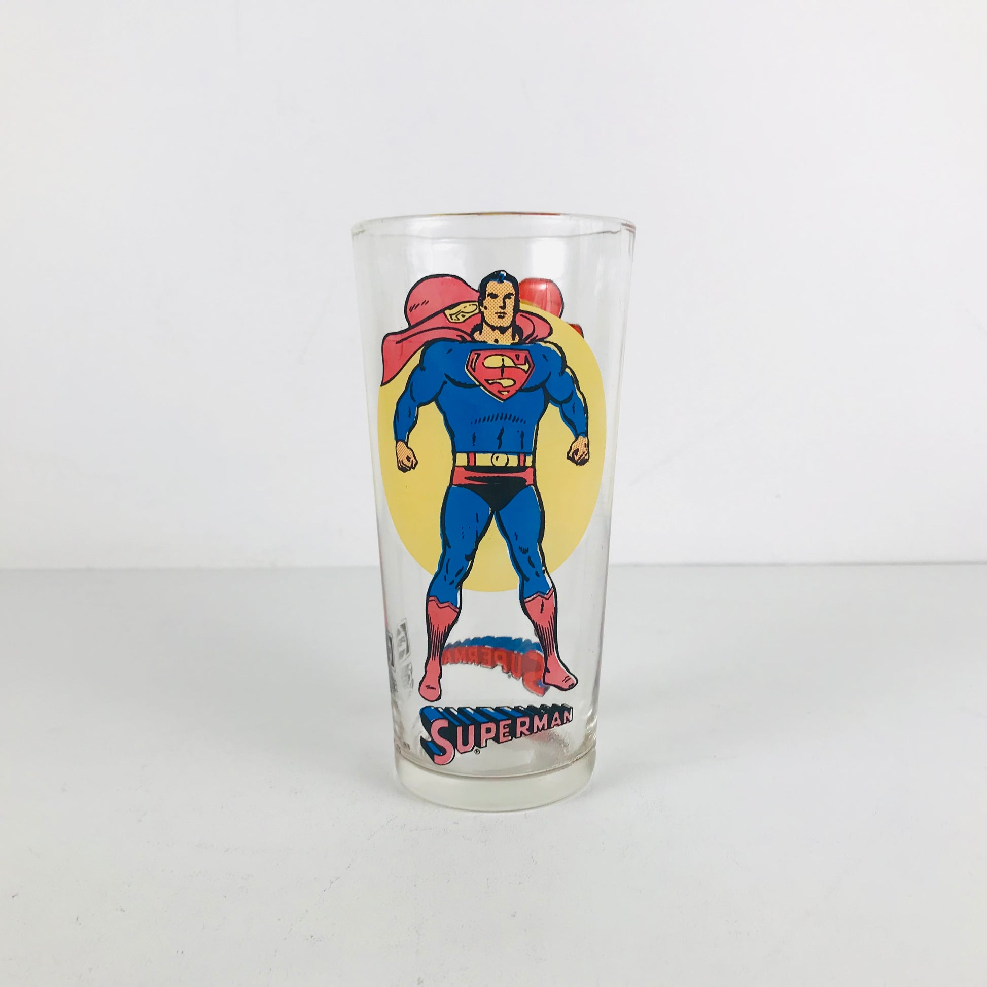 A 1970s Superman collectible glass tumbler showing an animated image of Superman
