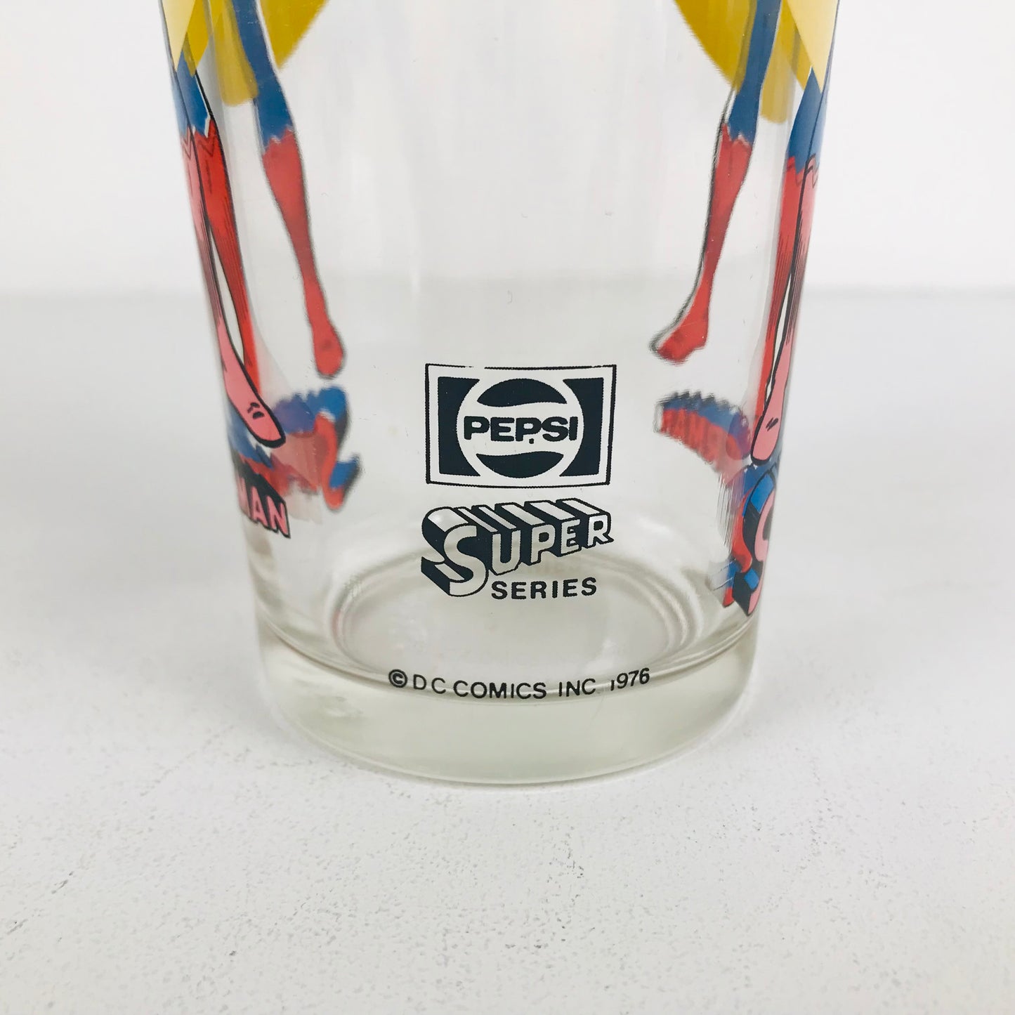 Back of a Superman glass showing the Pepsi Super Series logo and DC Comics product date of 1976