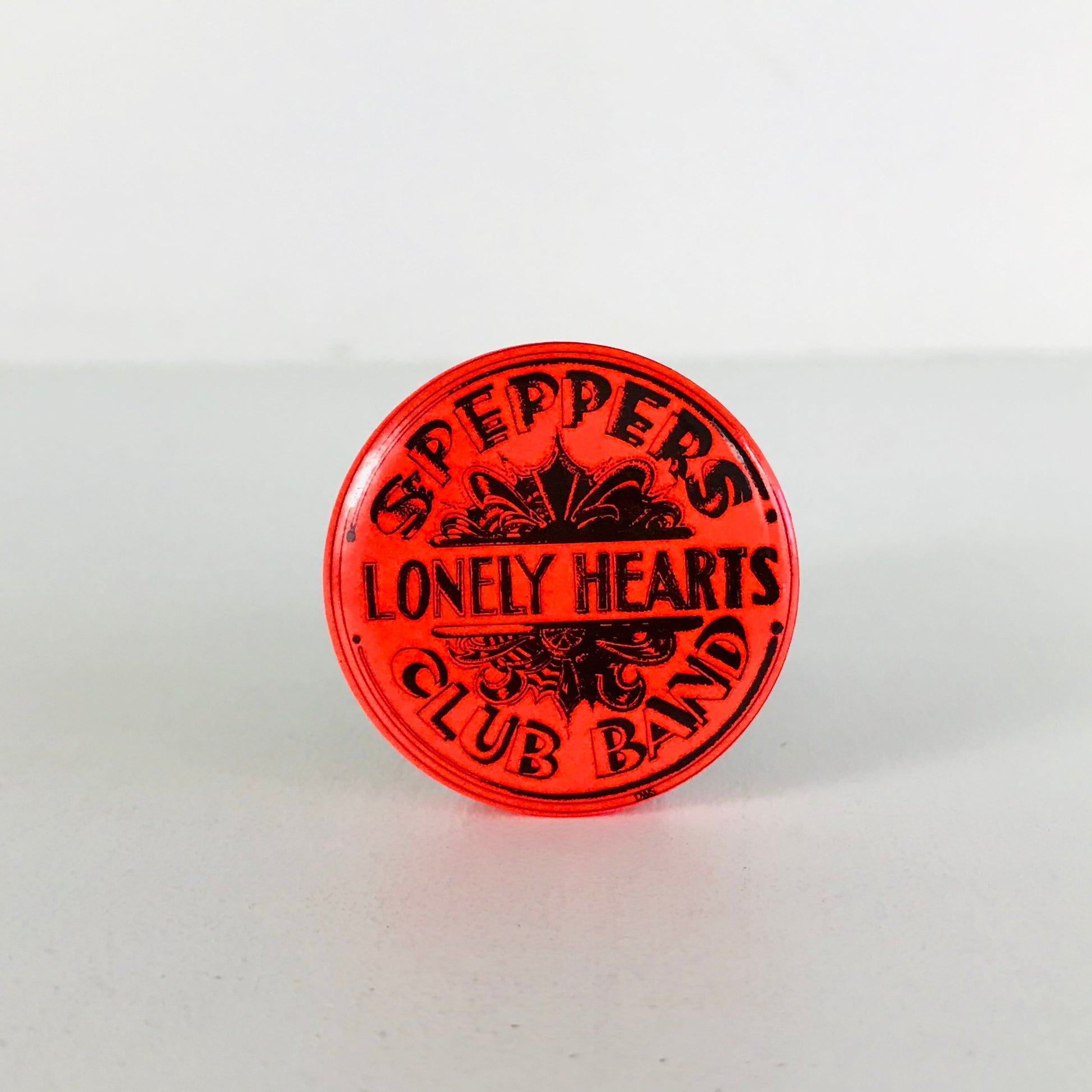 Close up view of a 1960s Beatles "Sgt. Pepper's Lonely Hearts Club Band" pinback button.