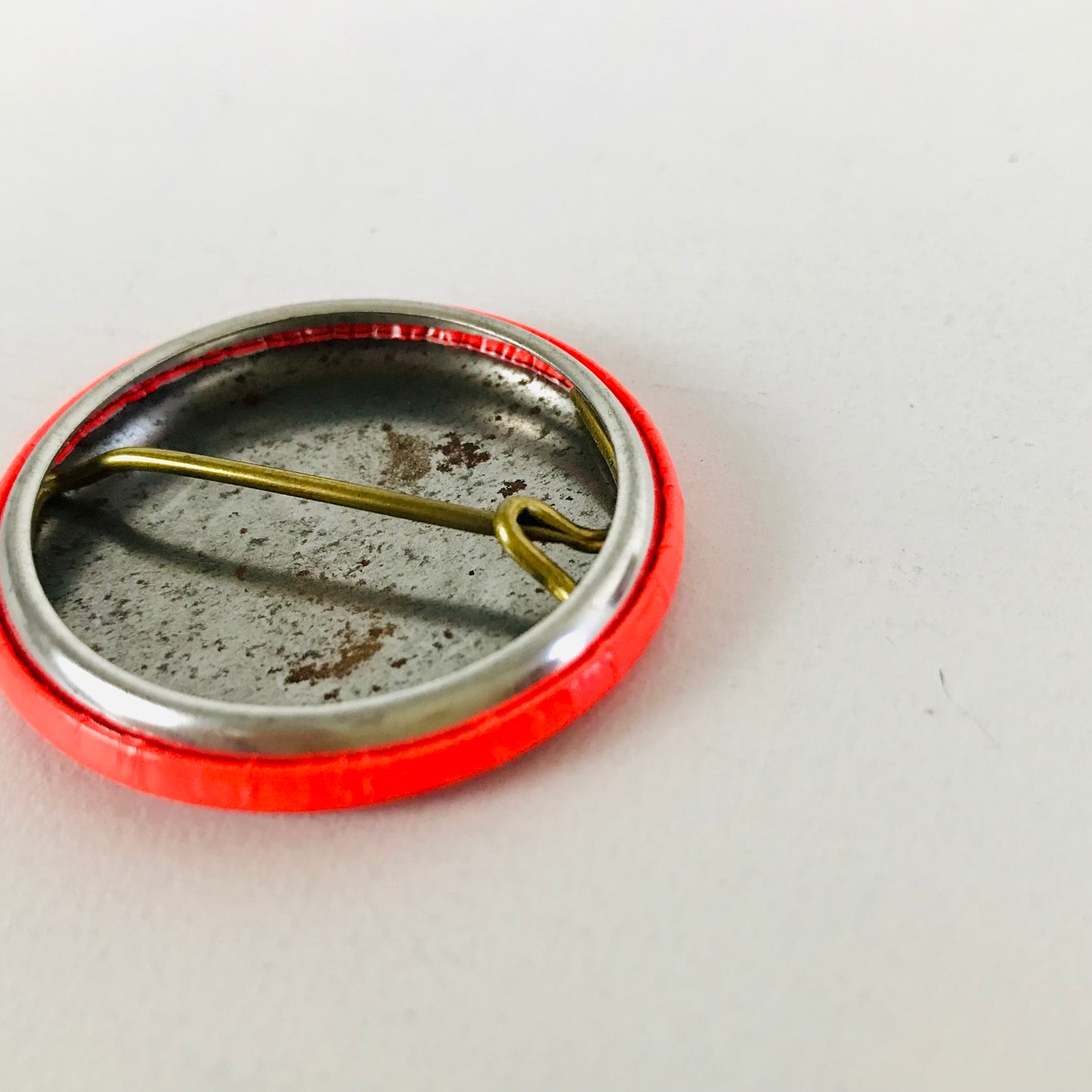 Close up image of the metal backing and pin closure of a 1960s Beatles pinback button collectible.