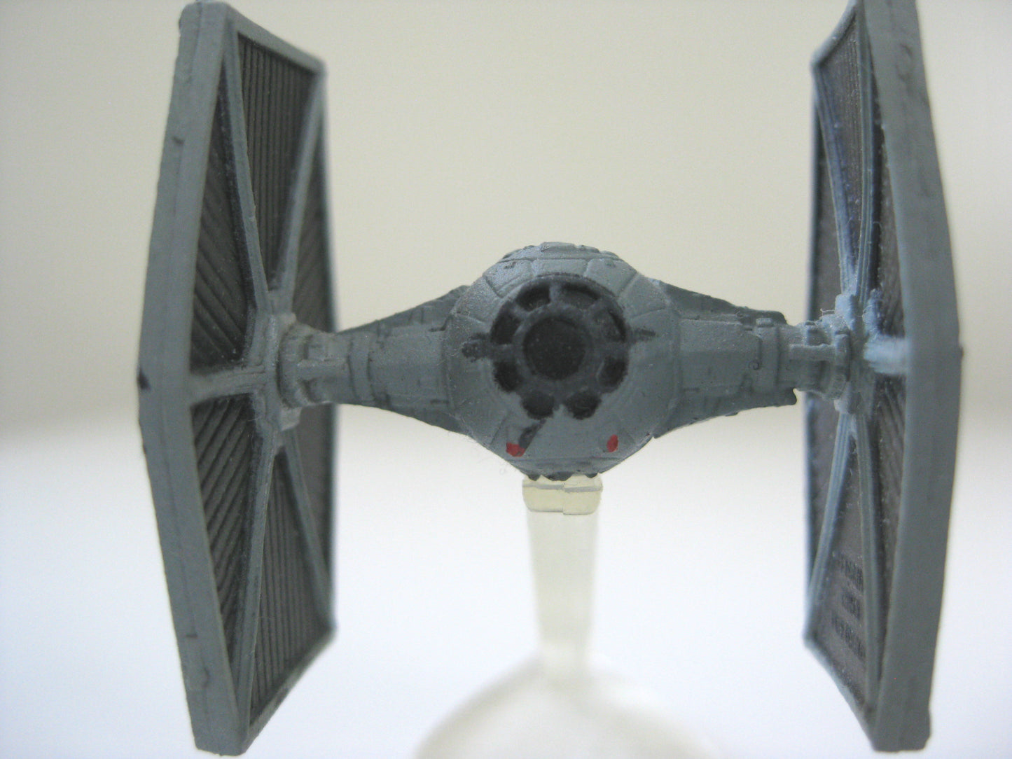 Close up cockpit view of a 1" miniature Star Wars TIE Fighter spaceship toy model.