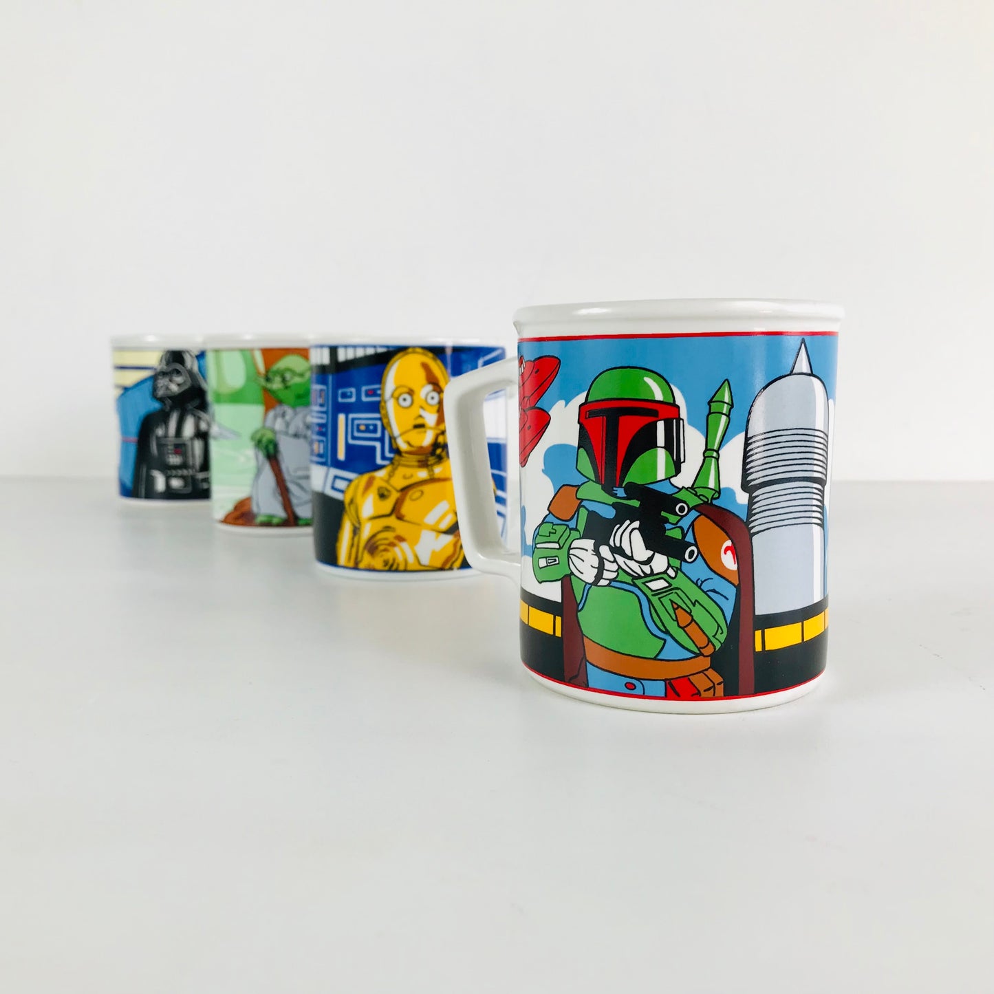 Vintage set of 1980s Sigma Star Wars Empire Strikes Back ceramic coffee mugs lined up in a row.