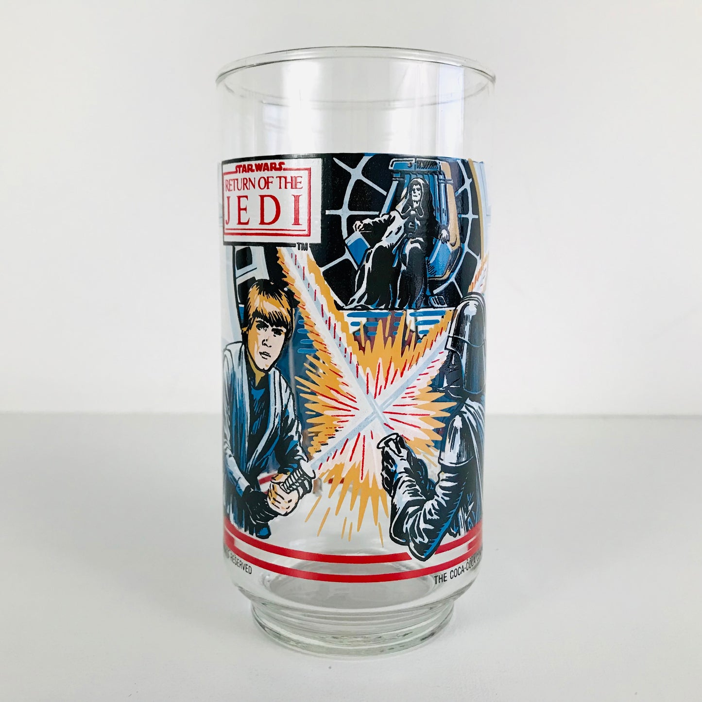 A 1983 Star Wars Burger King glass tumbler with Luke Skywalker battling Darth Vader on the front.