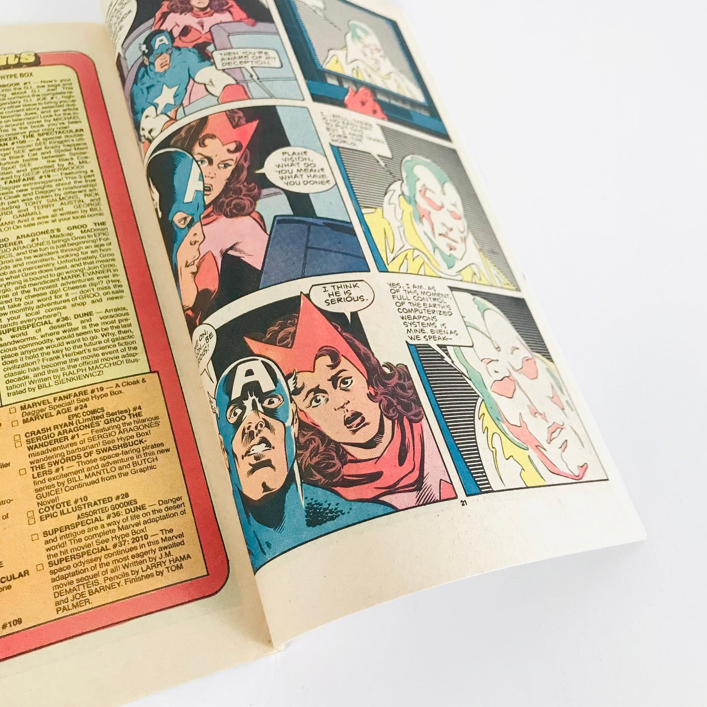 A close up look at a page from a Marvel Comics Avengers comic book featuring illustrations of Captain America, Scarlet Witch, and The Vision.