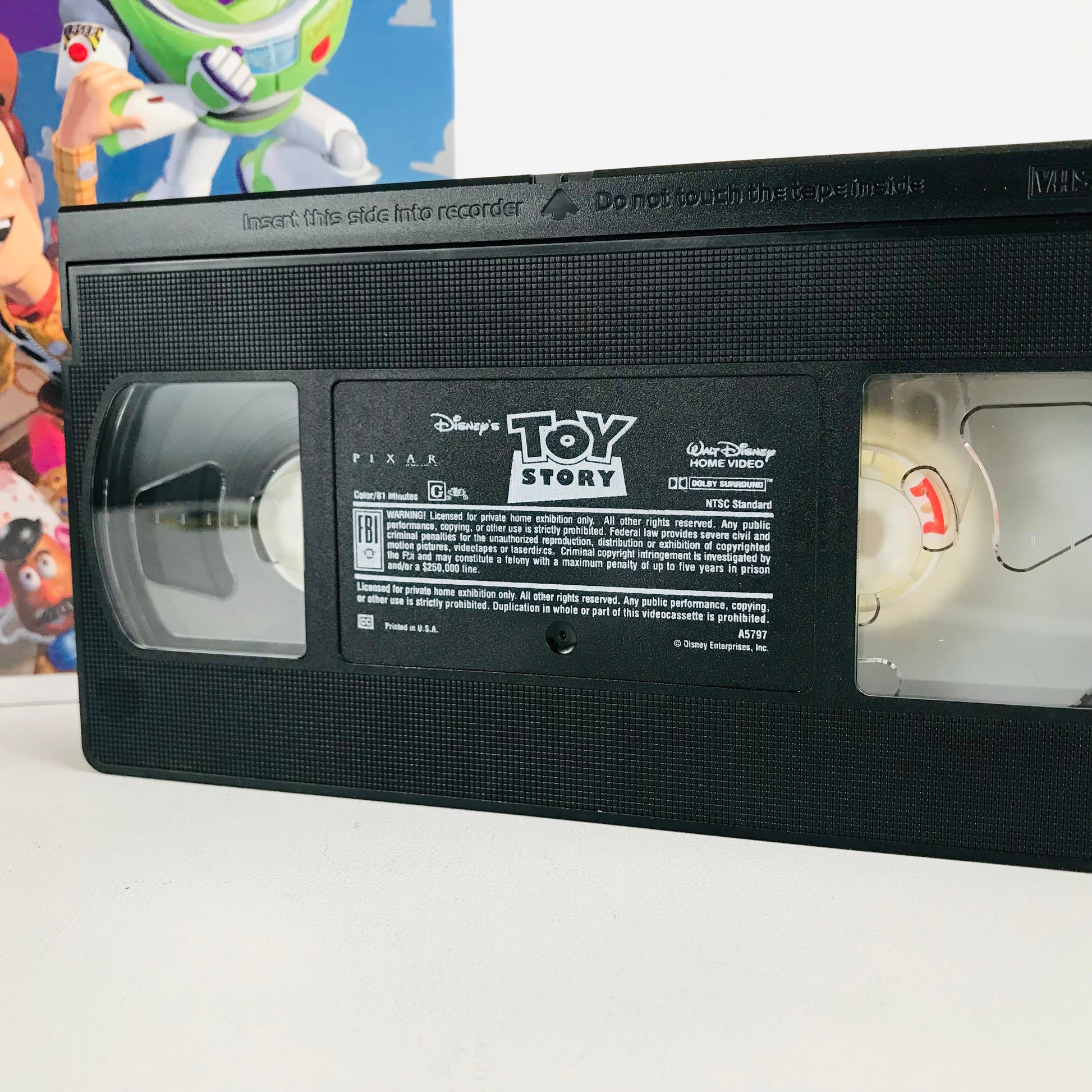 Close up look at a "Toy Story" VHS tape showing the rating and runtime of the film.