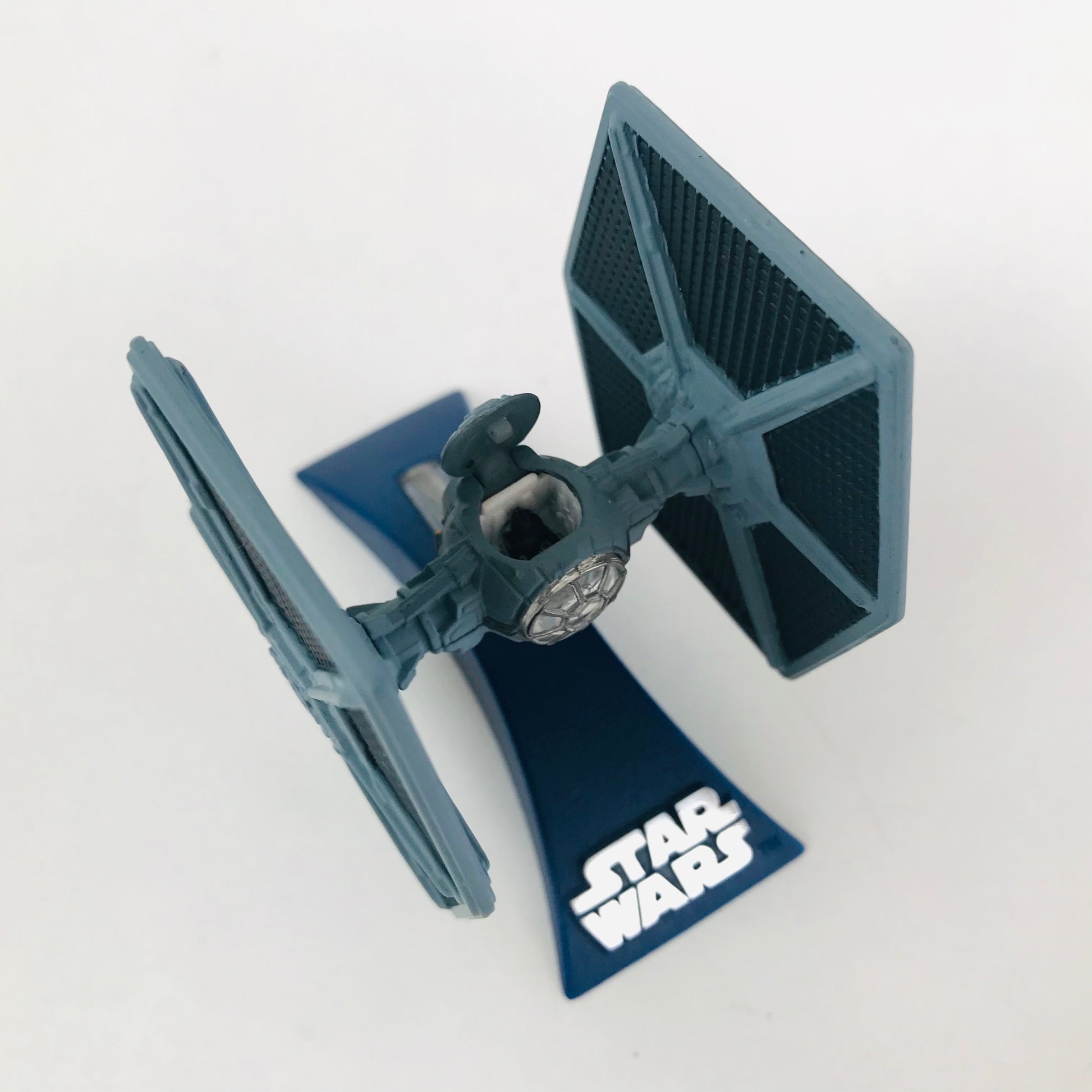 Overhead view of a miniature Star Wars die cast metal TIE Fighter showing the opening / closing cockpit.