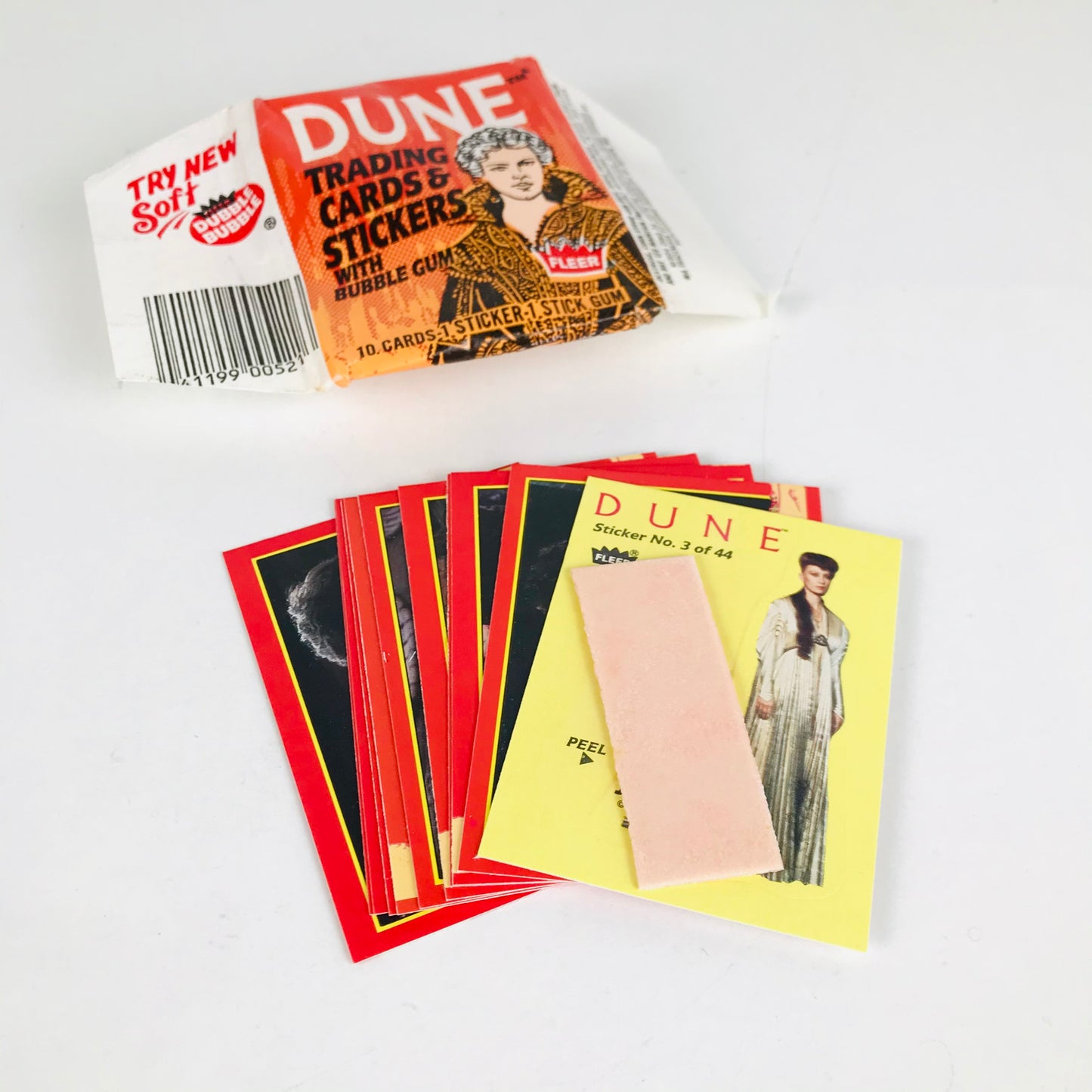 An opened pack of vintage Dune trading cards showing the wrapper, cards, and a stick of bubblegum